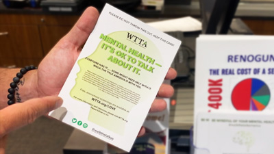 Firearm salesman handing WTTA mental health flyer to customer
