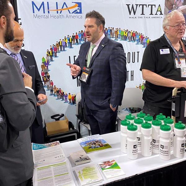 Michael Sodini talking to a guest at the WTTA booth during SHOT Show