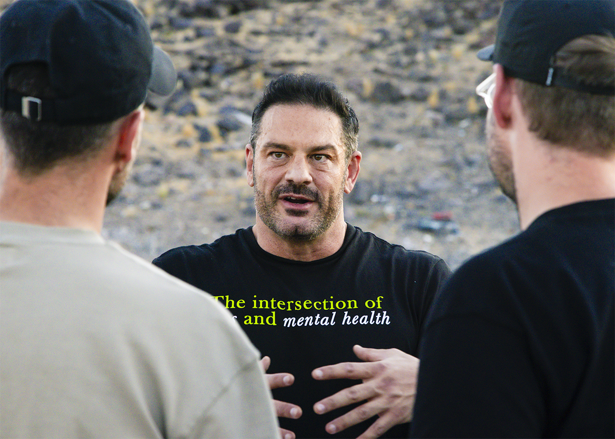 Michael Sodini gestures while explaining something to two other people.